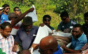 އަލީގެ ހަށިގަނޑު ނަގައިގެން އެމްބިއުލާންސަށް އަރުވަނީ: އޭނާ ފެނުނީ މަރާލައިފައި އެއްލާލައިފައި އޮޮއްވާ -- ފޮޓޯ: ކިއުންތެރިއެއް